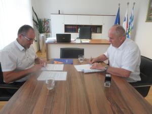 Boštjan Čokl, predstavnik podjetja Nomago, in župan Stanislav Šket med podpisom pogodbe. 